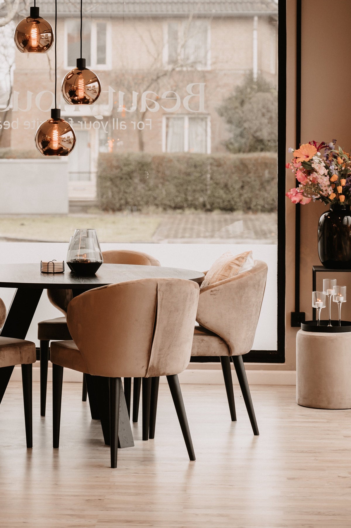Modern dining area with a round table and chairs near a large window.